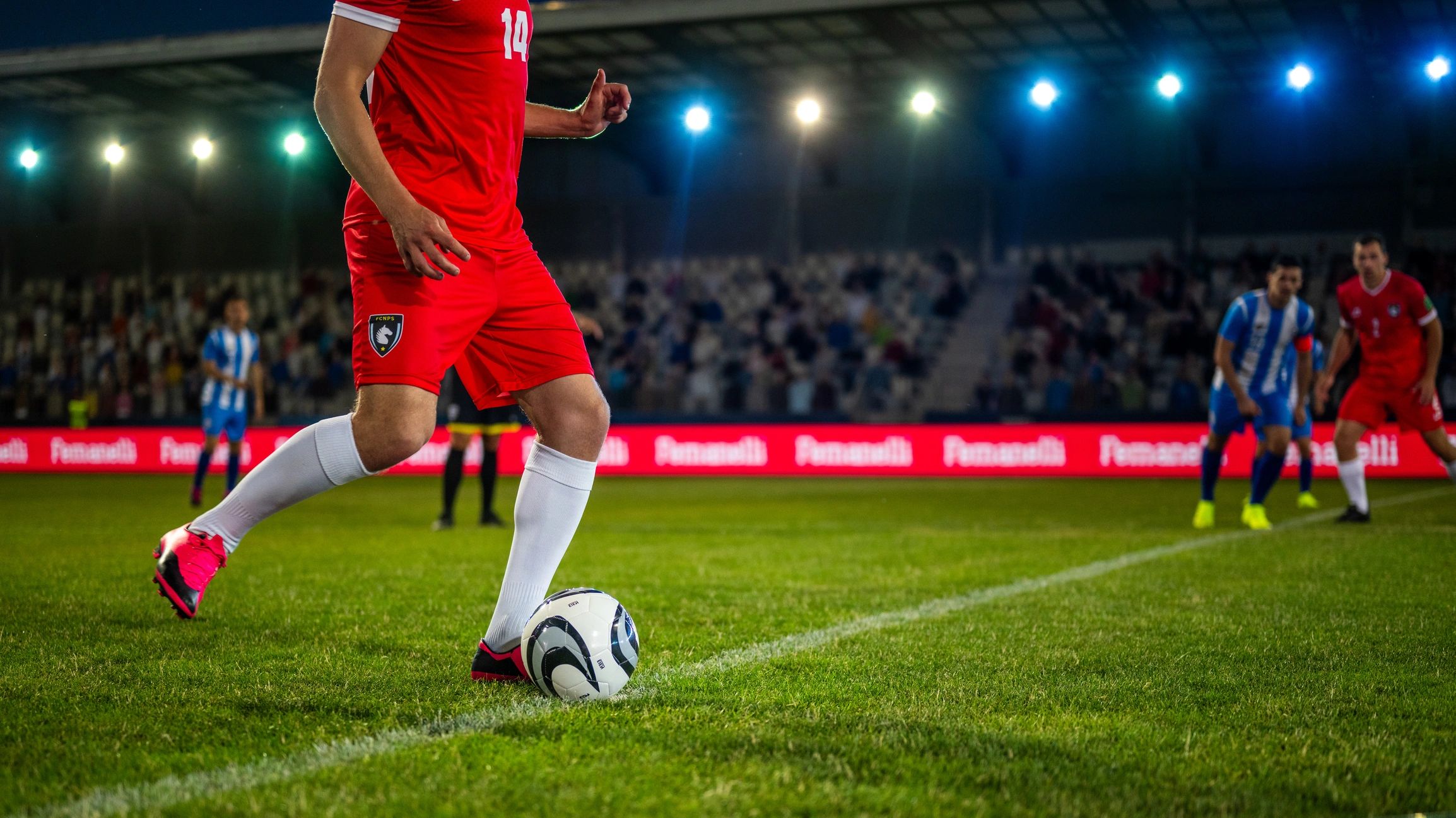 Soccer player kicking off on a sports field